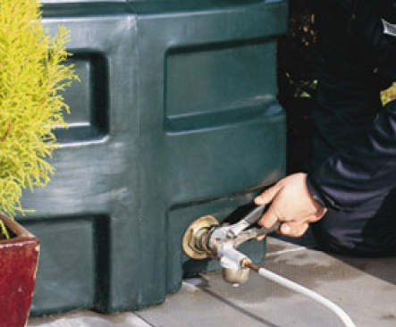 Engineer connecting the fuel line to a bunded oil tank during an installation