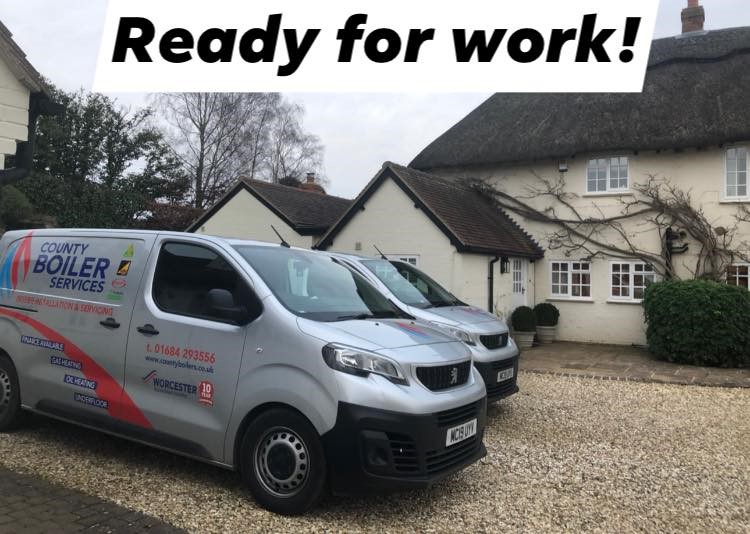 County Boiler Services vans parked outside a customer's thatched cottage, ready for work